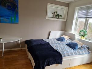 um quarto com uma cama com lençóis azuis e uma mesa em Kaldvell Apartman em Lillesand
