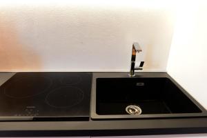 a kitchen sink with a faucet on top of it at Cùninarum Domus in Alghero +28 photos