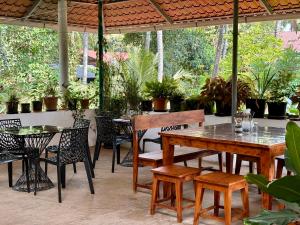 a patio with tables and chairs and potted plants at Gloria Homestay ,Thrissur in Trichūr