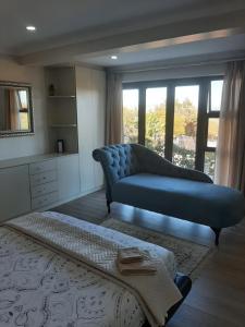 a living room with a blue couch and a large window at Luxury flat with magnificent views in Plattrkloof in Cape Town +12 photos