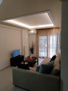 uma sala de estar com um sofá e uma mesa em ALEX HOUSE em Kavala