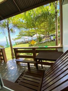 a porch with two benches and a view of the ocean at Oceanfront Beach Resort in Siquijor