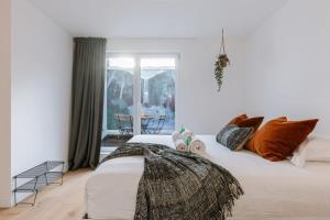 1 dormitorio con 1 cama blanca grande con almohadas en Homely duplex near historic city center & station, en Gante