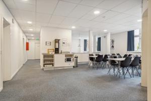 a room with chairs and a kitchen and a table at BB-Hotel Vejle Park in Vejle