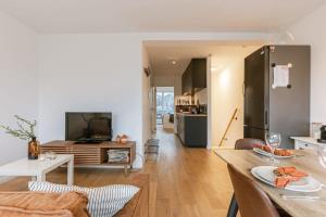 a living room with a table and a kitchen at Homely duplex near historic city center & station in Ghent