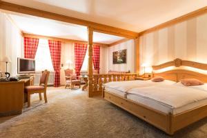 a bedroom with a large bed and a desk at Hotel Elfbuchen in Kassel