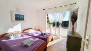 Un dormitorio con una cama con sábanas moradas y una ventana. en belle villa vue mer avec piscine chauffée 4 chambres - baccalocation, en Cirendinu 16 fotos más