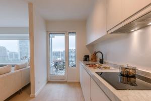 a kitchen with a counter and a large window at Huswell - Luminous family apartment with magnificent view in Ostend
