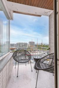 a balcony with two chairs and a table at Huswell - Luminous family apartment with magnificent view in Ostend