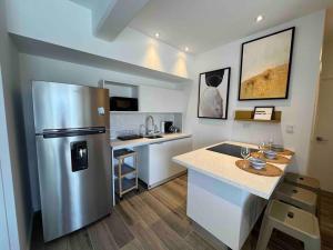 a kitchen with a stainless steel refrigerator and a counter at Ua ua - Comfortable apartment in Guatemala