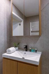 W łazience znajduje się biała umywalka i lustro. w obiekcie Bright family apartment with magnificent view w Ostendzie