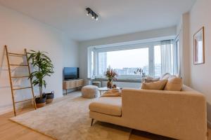 ein Wohnzimmer mit einem Sofa und einem großen Fenster in der Unterkunft Bright family apartment with magnificent view in Ostende