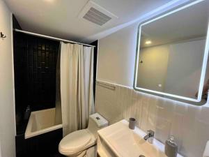 a bathroom with a toilet and a sink and a mirror at Ua ua - Comfortable apartment in Guatemala