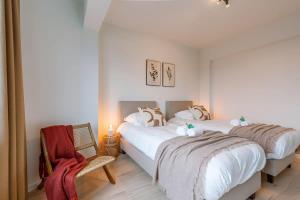 sypialnia z 2 łóżkami i krzesłem w obiekcie Bright family apartment with magnificent view w Ostendzie