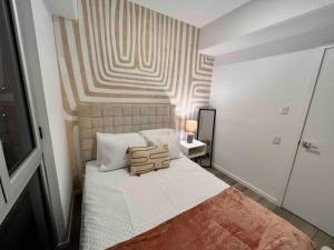 een slaapkamer met een bed met een gestreepte muur bij Ua ua - Comfortable apartment in Guatemala