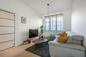 - un salon avec un canapé et une télévision dans l'établissement House with large and sunny terrace, à Anvers