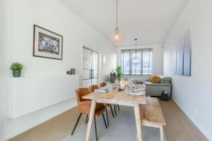 een eetkamer en een woonkamer met een tafel en stoelen bij House with large and sunny terrace in Antwerpen