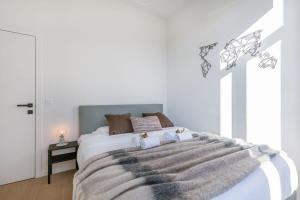 sypialnia z dużym łóżkiem i szarym kocem w obiekcie House with large and sunny terrace w Antwerpii