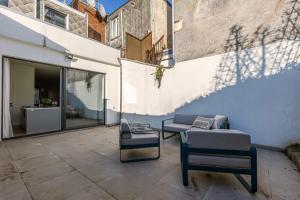 un patio con 2 sillas y un sofá en House with large and sunny terrace, en Amberes