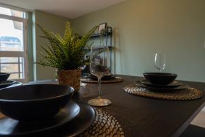 a table with black plates and wine glasses on it at City Centre - 2BR Apt - Free Parking - Long Stays in Nottingham
