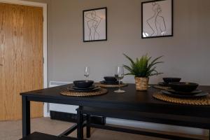 a dining room table with plates and wine glasses at City Centre - 2BR Apt - Free Parking - Long Stays in Nottingham