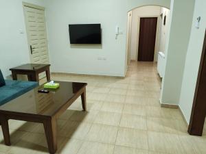 a living room with a coffee table and a tv at CMK Housing in Madaba