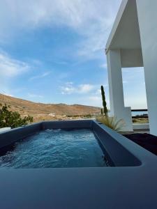 a swimming pool in front of a white house at Vie rêvée luxury suites in Ganema