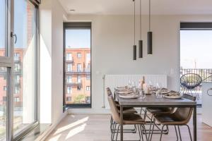 een eetkamer met een tafel en stoelen bij Spacious apartment with beautiful terrace near Ghent in Gent