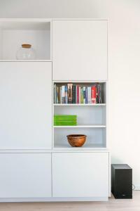 a white book shelf with a bowl on it at Spacious apartment with beautiful terrace near Ghent in Ghent