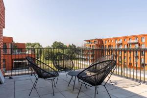 three chairs and a table on a balcony at Spacious apartment with beautiful terrace near Ghent in Ghent