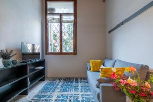 a living room with a blue couch and a window at Duomo5 Flat - Vicenza Centro Storico in Vicenza