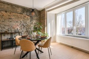 jadalnia z ceglaną ścianą oraz stołem i krzesłami w obiekcie Industrial apartment with terrace in Antwerp w Antwerpii