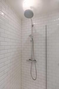 een douche in een badkamer met witte tegels bij Modern 2 bedroom in centre of Knokke in Knokke-Heist