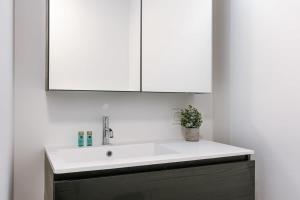 a bathroom with a white sink and a mirror at Pleasant apartment at the lighthouse in Ostend in Ostend