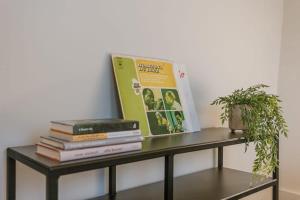 a group of books on a table with a plant at WAY SWEET DREAMS - Room 5 in Ghent