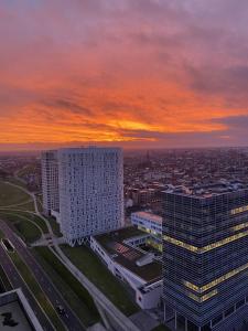 a sunset over a city with two tall buildings at Huswell - Beautiful apartment in the heart of Antwerp in Antwerp