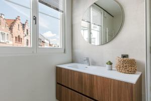 a bathroom with a sink and a mirror at Modern apartment in the centre of Antwerp in Antwerp