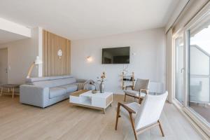 ein Wohnzimmer mit einem Sofa und einem Tisch in der Unterkunft Bright seaview apartment in Oostende in Ostende