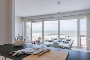 eine Küche mit einem Tisch und Meerblick in der Unterkunft Bright seaview apartment in Oostende in Ostende