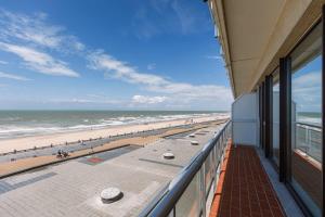 Blick auf den Strand vom Balkon eines Gebäudes in der Unterkunft Bright seaview apartment in Oostende in Ostende