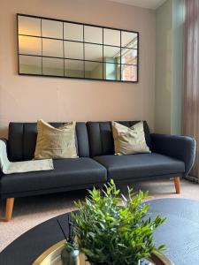 a living room with a blue couch and a mirror at City Centre - 2BR Apt - Free Parking - Long Stays in Nottingham