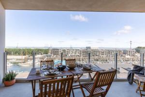 ein Esszimmer mit einem Tisch und Stühlen sowie einem großen Fenster in der Unterkunft Brand new apartment with stunning harbor views in Brügge