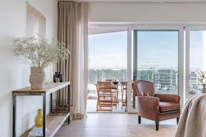 ein Wohnzimmer mit einem Stuhl und einem Tisch in der Unterkunft Brand new apartment with stunning harbor views in Brügge