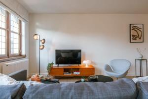 sala de estar con sofá y TV en Modern apartment on top location in Antwerp, en Amberes