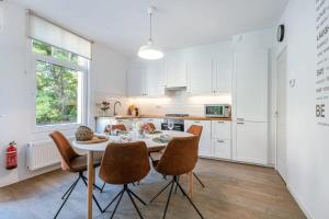 a white kitchen with a table and chairs at Great apartment in the heart of Ypres in Ieper