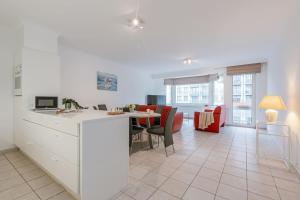 a kitchen and living room with a table and chairs at Modern apartment with parking and sea view in Oostduinkerke in Oostduinkerke