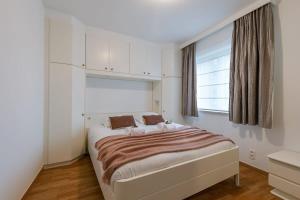 a bedroom with a large bed with a window at Modern apartment with parking and sea view in Oostduinkerke in Oostduinkerke