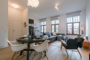 ein Wohnzimmer mit einer Couch und einem Tisch und Stühlen in der Unterkunft Huswell - Modern apartment located at historical Main Square in Antwerpen