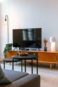 ein Wohnzimmer mit Fernseher und Couchtisch in der Unterkunft Huswell - Modern apartment located at historical Main Square in Antwerpen + 17 Fotos