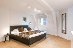una camera da letto con un letto grande in una stanza bianca di Huswell - Stunning apartment at the Grand Market of Antwerp ad Anversa